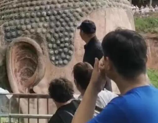 景区回应一男子爬上乐山大佛头顶 警方将会依法依规处理此事